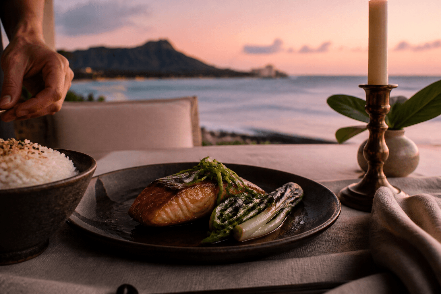 Miso-glazed catch on dark ceramic on a Kahala lānai at dusk, Diamond Head on the horizon.