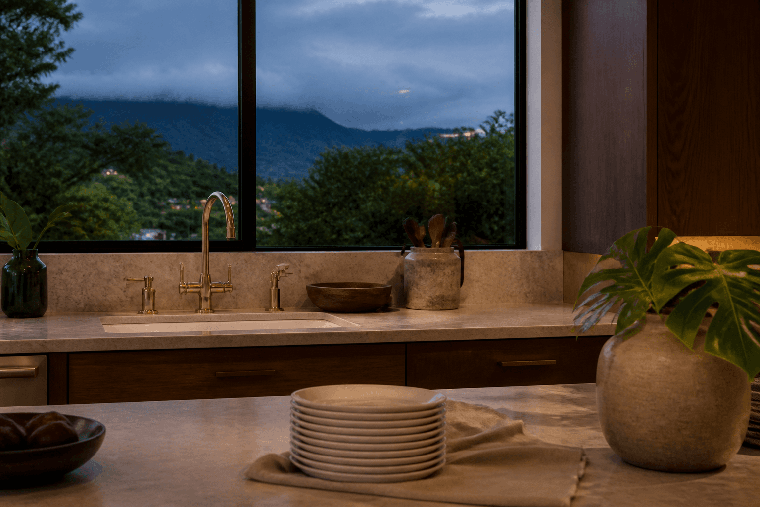 A Kāneʻohe windward household kitchen at dusk, unused ivory plates, moss-green through a window.